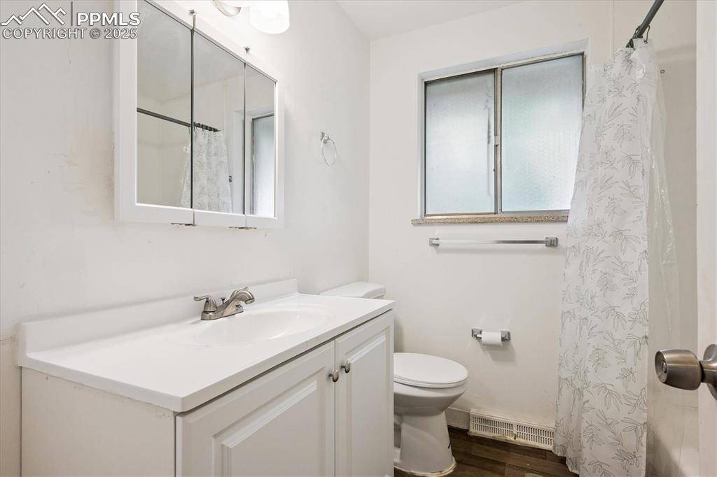 Image 10 of 19: Full bathroom featuring dark wood-style flooring, a shower with shower curt