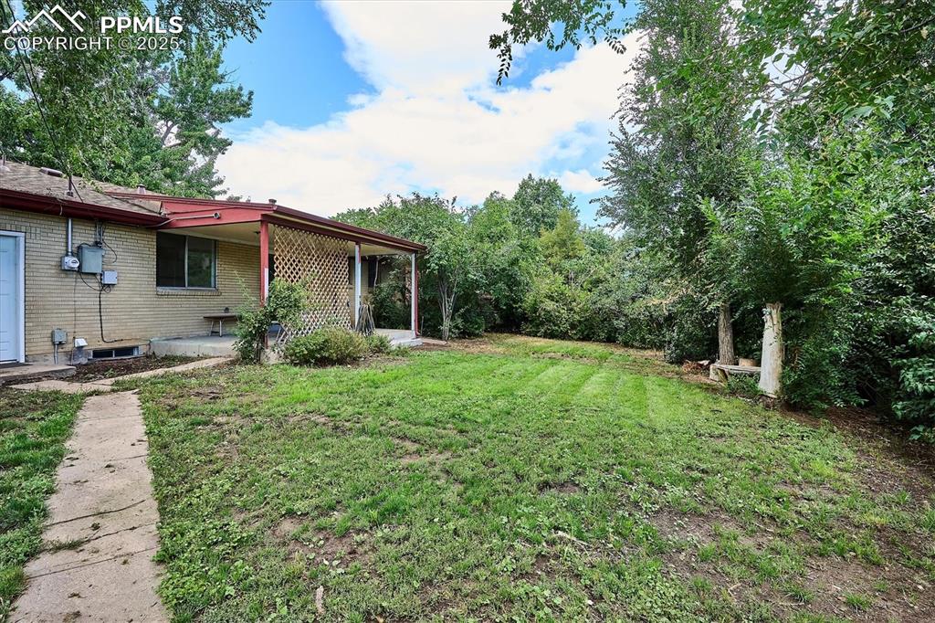 Image 17 of 19: View of green lawn with a patio