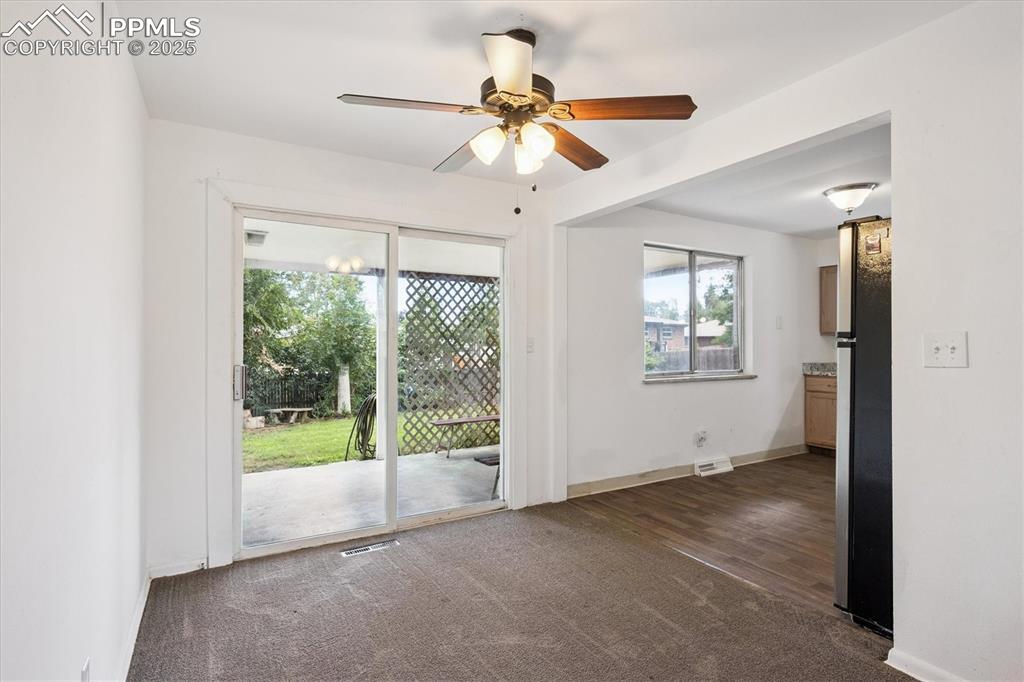 Image 4 of 19: Unfurnished room featuring dark carpet and a ceiling fan