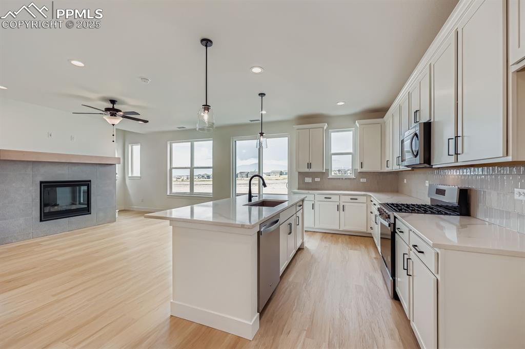 Image 12 of 28: Kitchen with stainless steel appliances, decorative backsplash, recessed li