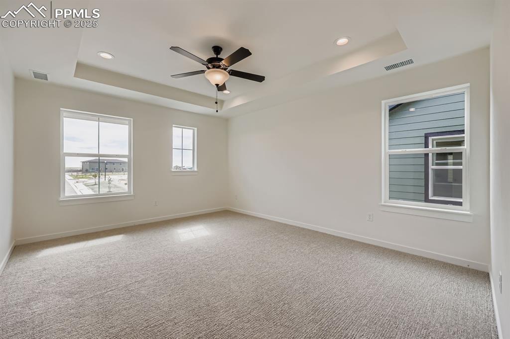 Image 14 of 28: Carpeted spare room with a raised ceiling, recessed lighting, and ceiling f