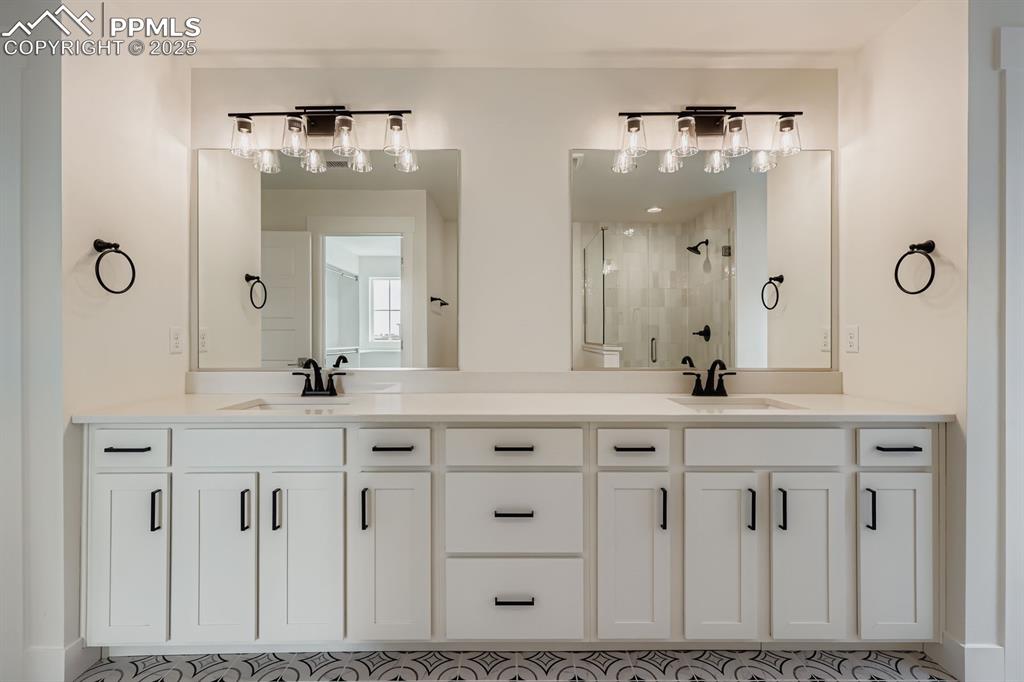 Image 19 of 28: Bathroom featuring a stall shower and double vanity