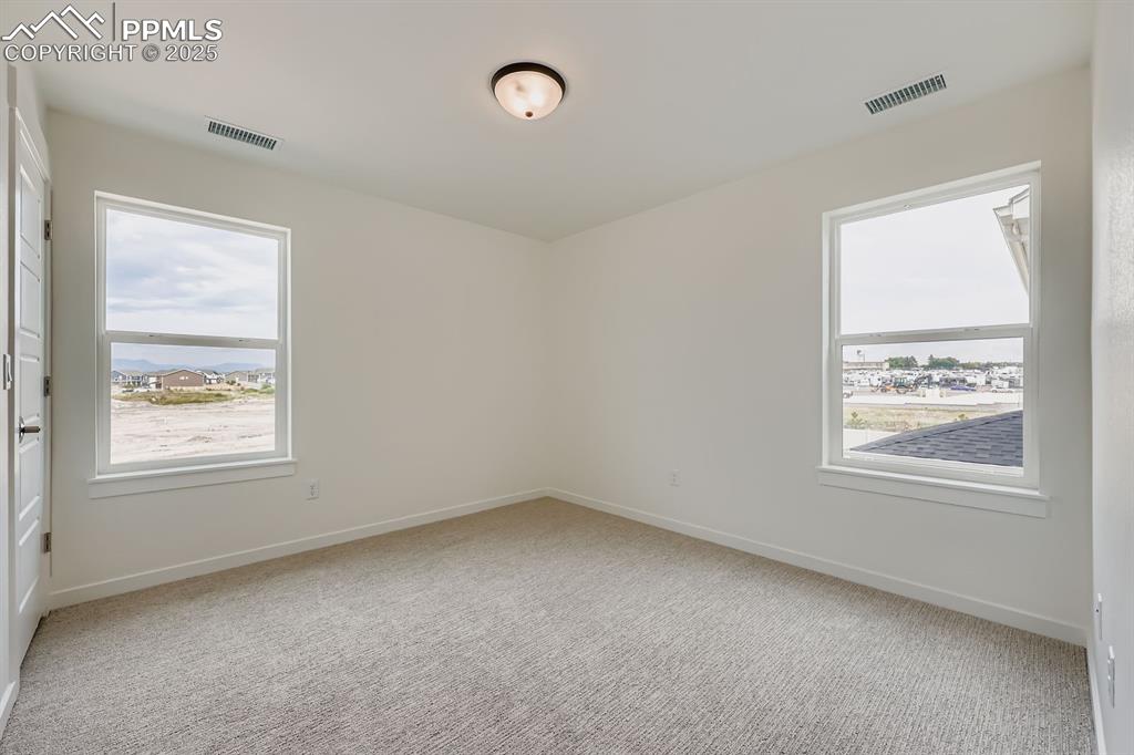 Image 23 of 28: Carpeted spare room featuring baseboards