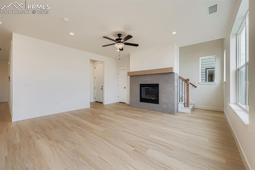 Image 8 of 28: Unfurnished living room with a ceiling fan, light wood-type flooring, reces