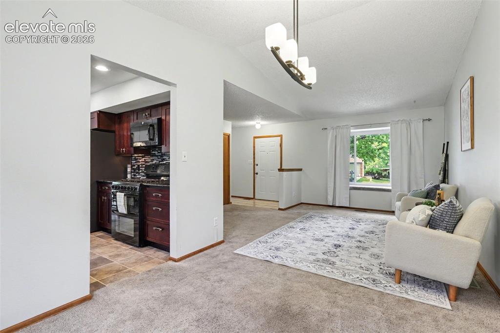 Image 12 of 41: From designated dining area looking at front door w/ kitchen entry on the l