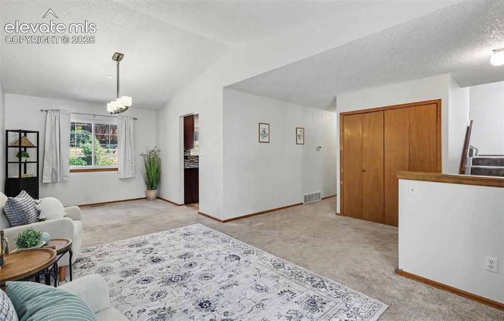 Image 13 of 41: Living area w/ hallway and kitchen entry in the center