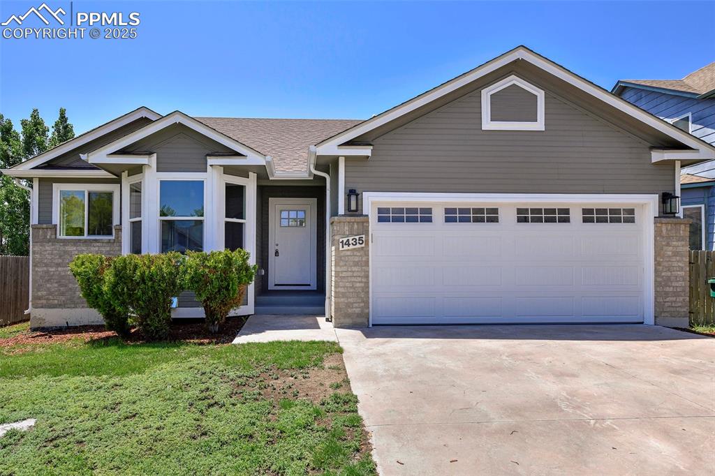 Image 20 of 44: View of front of home with a garage, concrete driveway, and brick siding