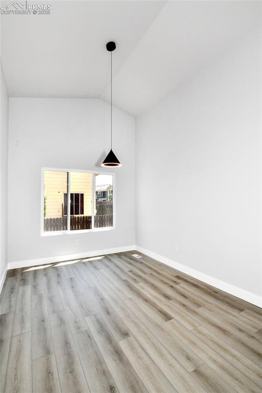 Image 28 of 44: Unfurnished dining area featuring wood finished floors and lofted ceiling