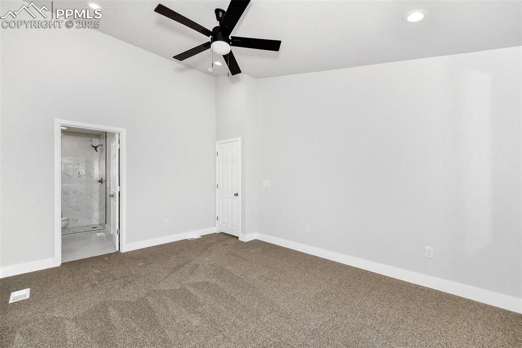 Image 35 of 44: Unfurnished bedroom with dark colored carpet, recessed lighting, ensuite ba