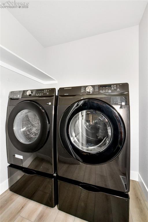 Image 44 of 44: Laundry room with washer and dryer and wood finished floors