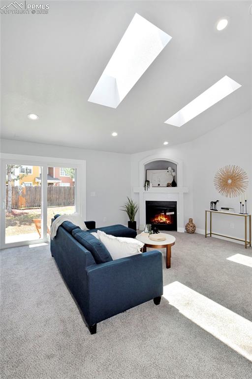 Image 9 of 44: Carpeted living room featuring recessed lighting, a glass covered fireplace
