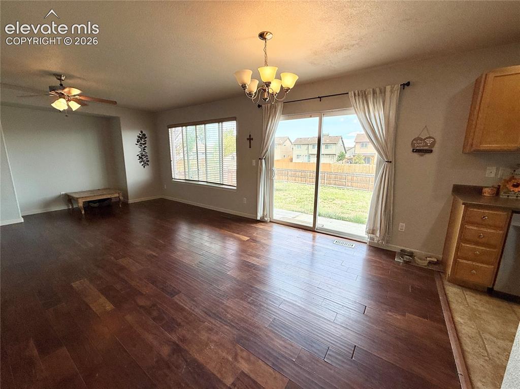 Image 5 of 16: Wood-finish flooring throughout, with a ceiling fan, a multi-light chandeli