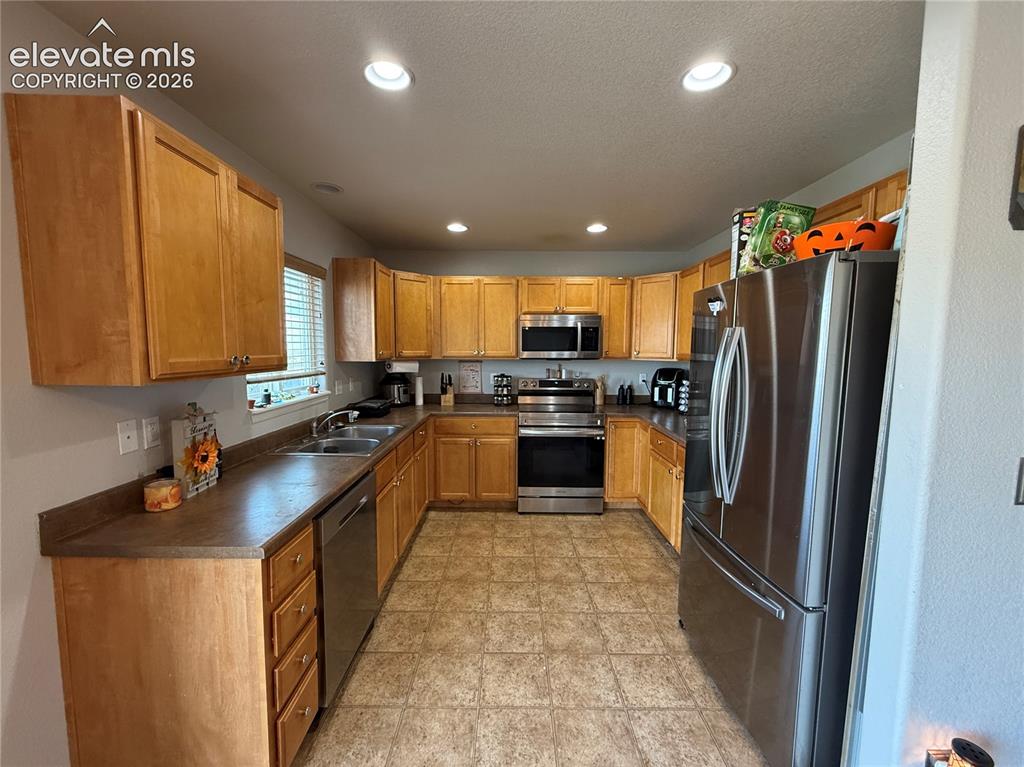 Image 6 of 16: U-shaped kitchen with wood-finish cabinetry, stainless steel appliances, du