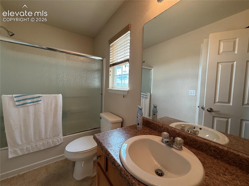 Image 9 of 16: Bathroom featuring a vanity with a drop-in sink, a large mirror, a shower-t