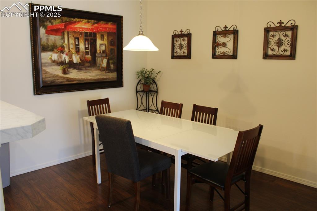 Image 10 of 20: Dining space with wood finished floors and baseboards