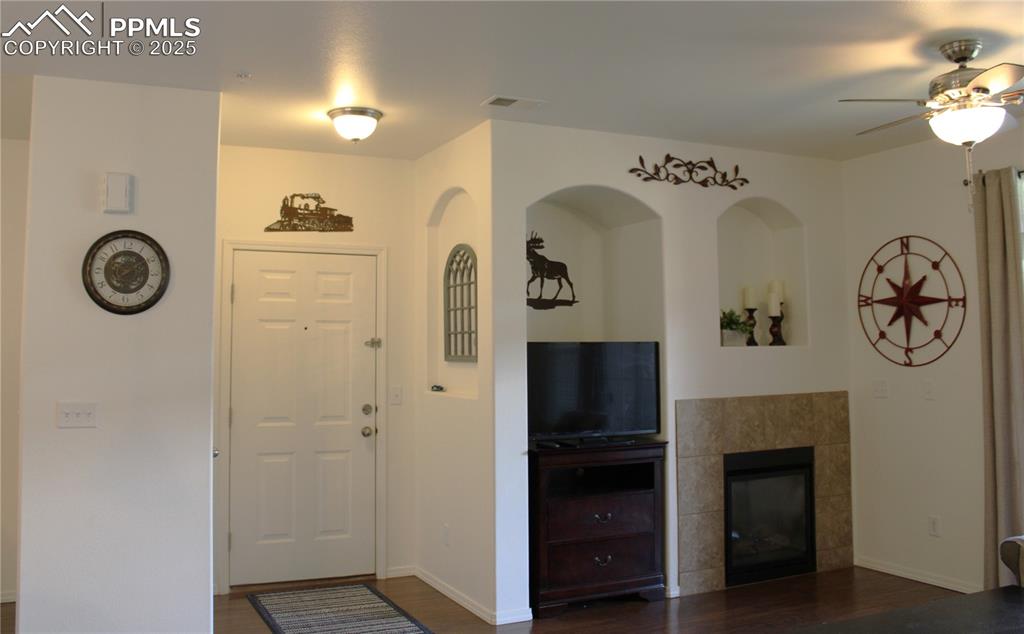 Image 11 of 20: Foyer featuring dark wood finished floors, a tiled fireplace, and a ceiling