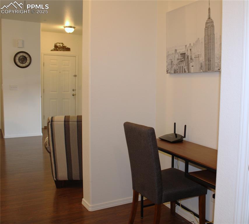 Image 19 of 20: Home office with baseboards and dark wood-style flooring