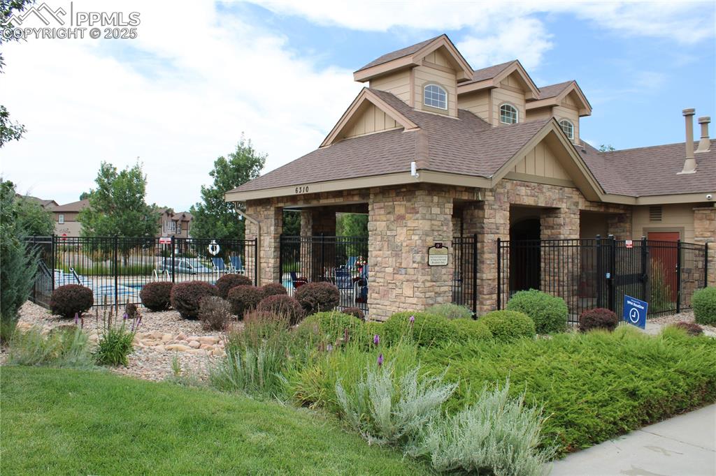 Image 5 of 20: View of front of property with roof with shingles and stone siding