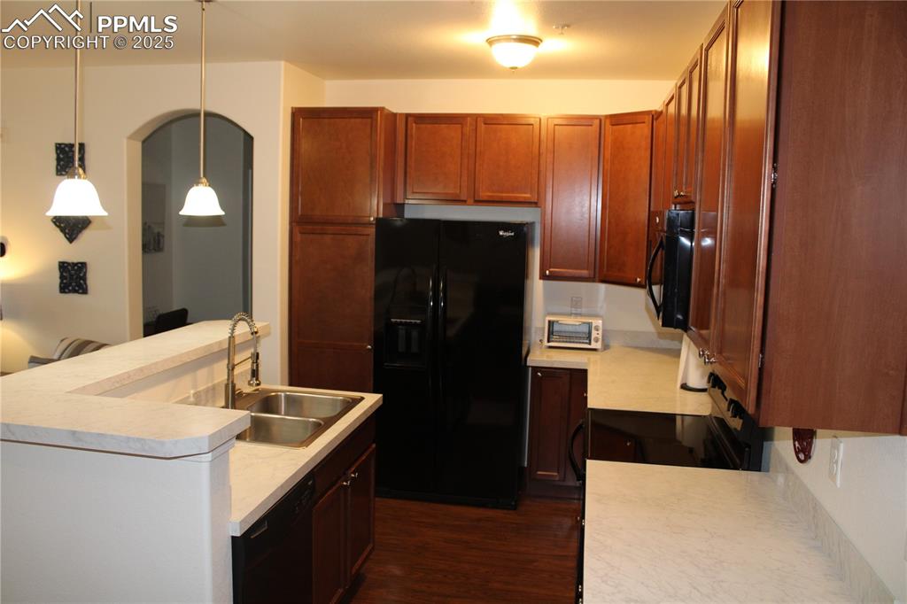Image 7 of 20: Kitchen featuring black appliances, dark wood-type flooring, light countert