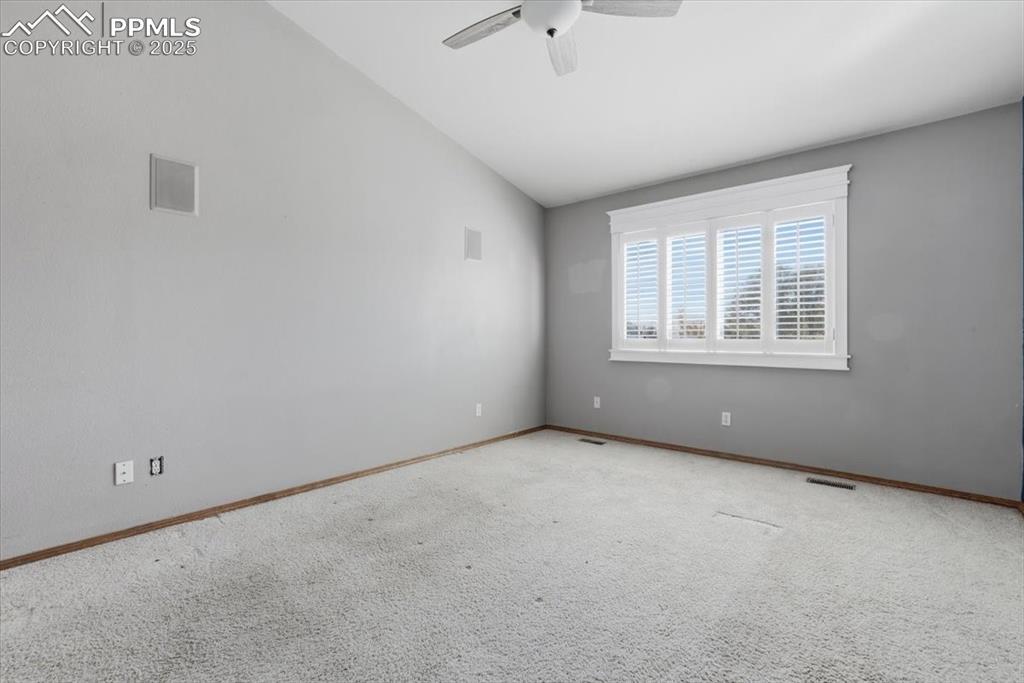 Image 10 of 43: Spare room with lofted ceiling, carpet, and ceiling fan
