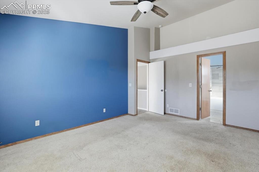 Image 11 of 43: Unfurnished bedroom with carpet flooring, a ceiling fan, and a high ceiling