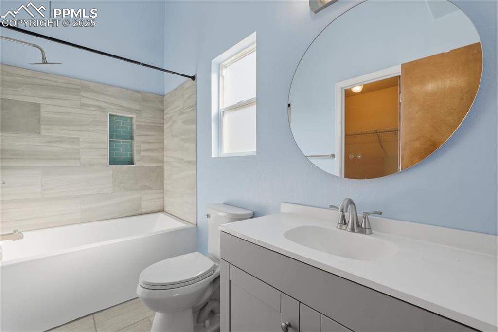Image 12 of 43: Bathroom featuring vanity, a spacious closet, and  shower combination