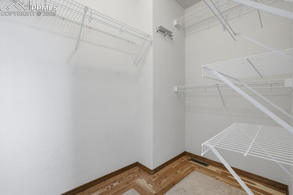 Image 13 of 43: Spacious closet with wood finished floors