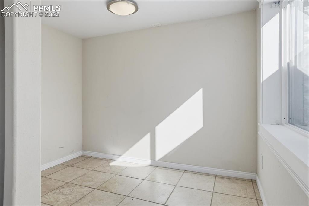 Image 23 of 43: Spare room with baseboards and light tile patterned floors
