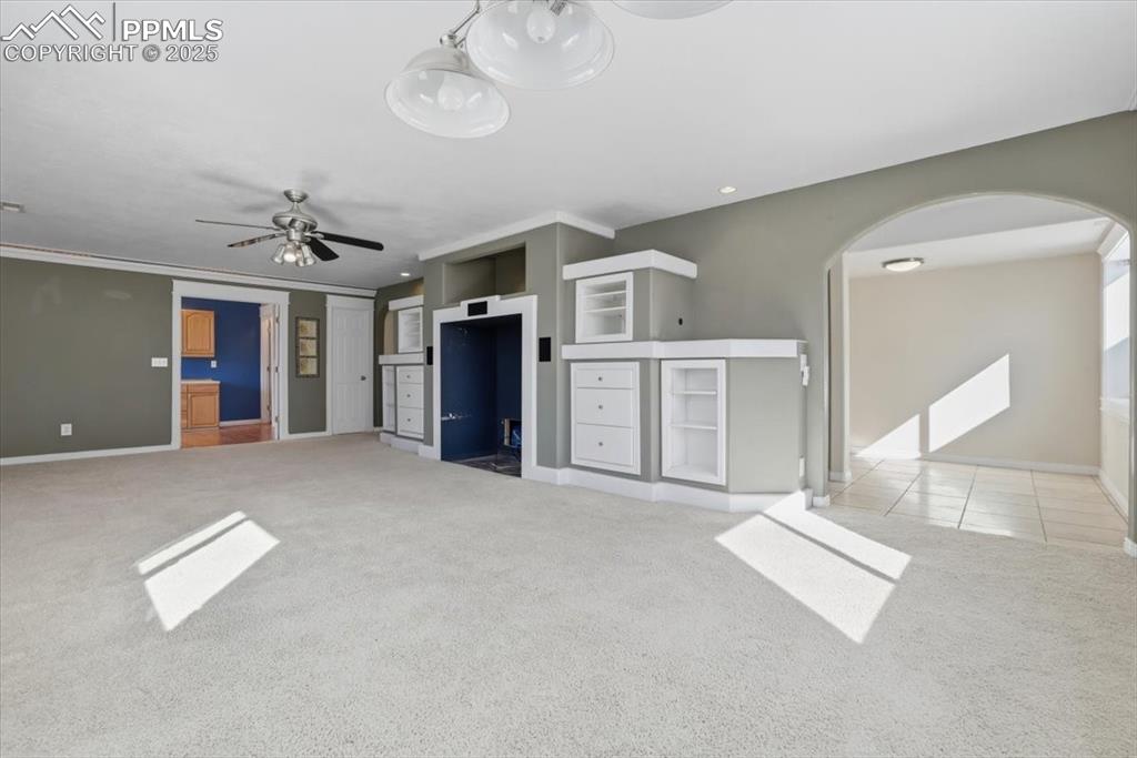 Image 26 of 43: Unfurnished living room with a ceiling fan, carpet floors, crown molding, a