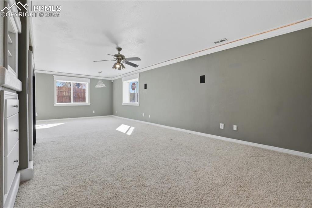 Image 29 of 43: Carpeted empty room featuring ornamental molding and a ceiling fan