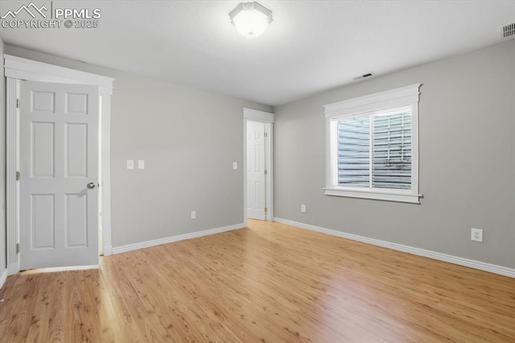 Image 34 of 43: Empty room with light wood-style floors and baseboards