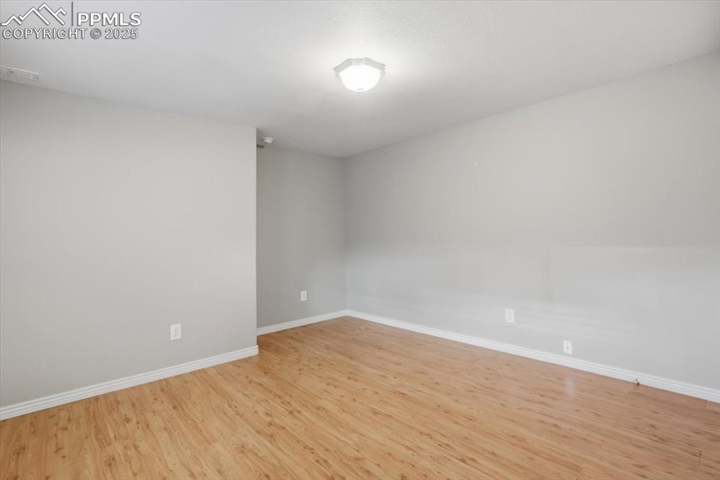 Image 36 of 43: Empty room with light wood-style flooring and baseboards