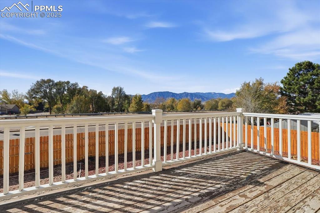 Image 40 of 43: Deck with a mountain view and a fenced backyard