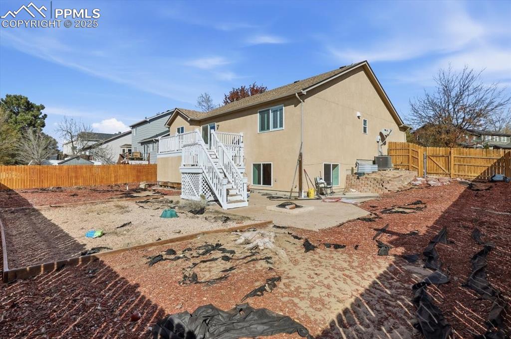 Image 42 of 43: Back of property featuring a fenced backyard, a patio, stucco siding, stair