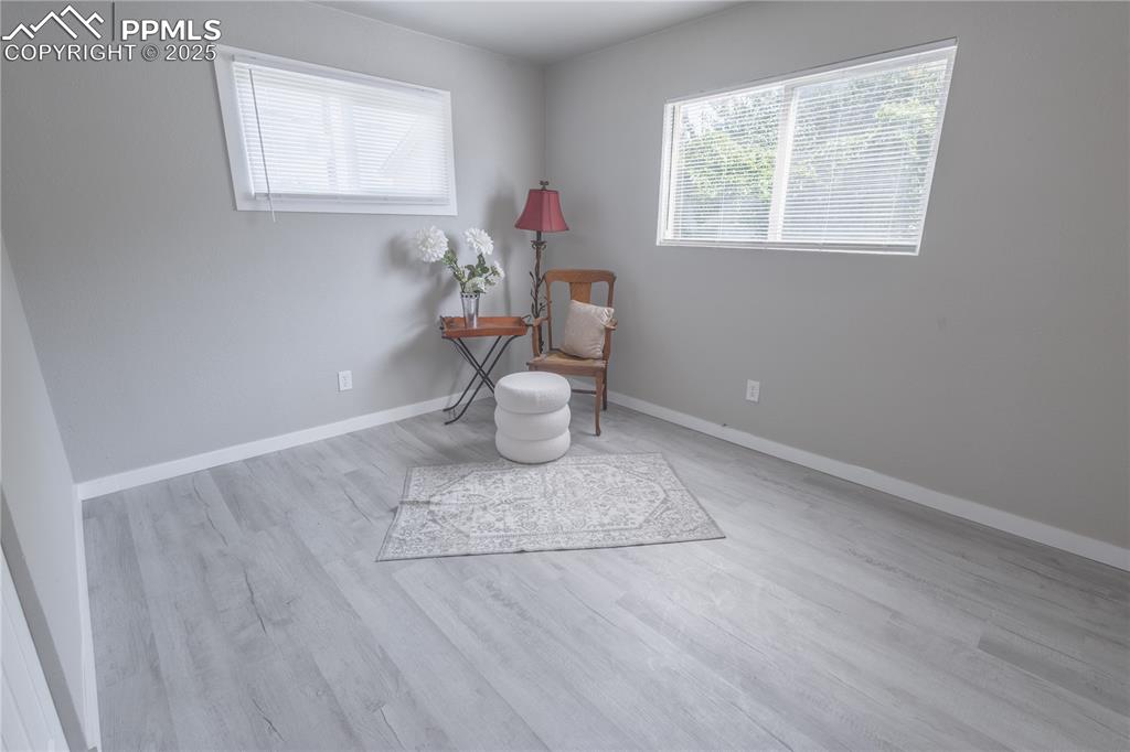 Image 14 of 21: Living area with baseboards and wood finished floors