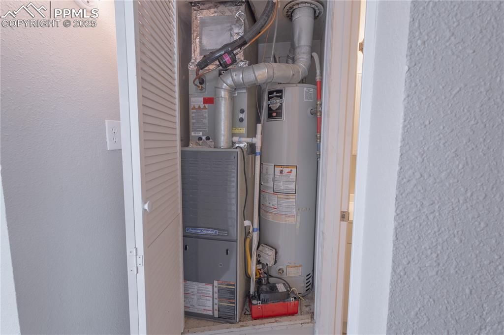 Image 18 of 21: Utility room featuring gas water heater and heating unit