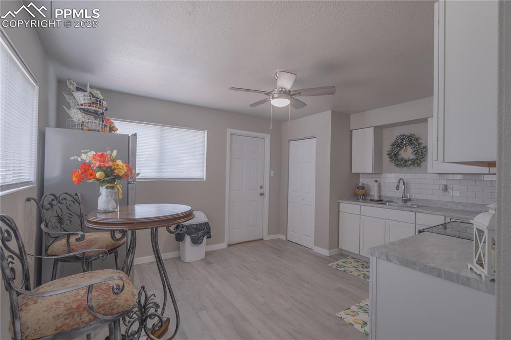 Image 5 of 21: Dining space featuring light wood finished floors, a ceiling fan, and a tex