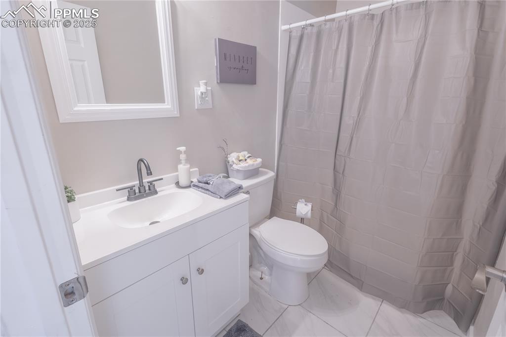 Image 9 of 21: Full bath with vanity, curtained shower, and light tile patterned floors