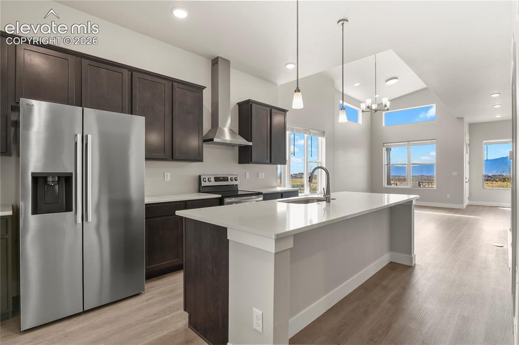 Image 7 of 50: Kitchen features a large center island, quartz counters, and stainless appl