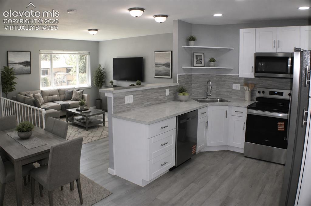 Image 10 of 28: Modern kitchen featuring white cabinetry, stainless steel appliances, and w