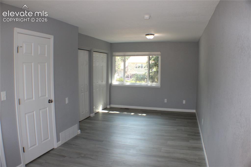 Image 12 of 28: Wood-finish flooring, white trim, and a window with natural light