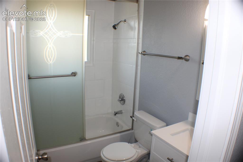 Image 16 of 28: Bathroom featuring a shower-tub combination with tile surround, frosted gla