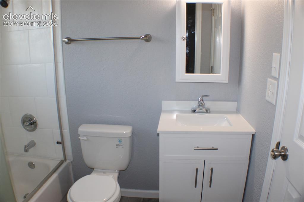 Image 17 of 28: White vanity with brushed nickel hardware, white countertop, and integrated