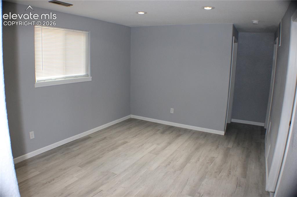 Image 18 of 28: Wood-finish flooring, recessed ceiling lighting, light gray wall paint, and
