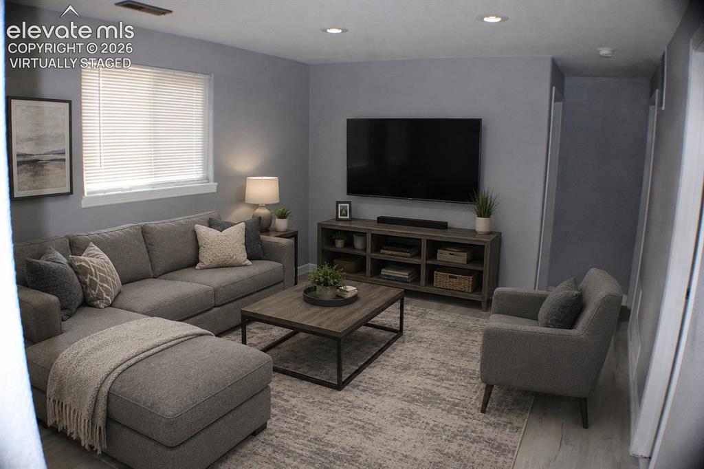 Image 19 of 28: Recessed lighting, wood-finish flooring, and window blinds virtually staged
