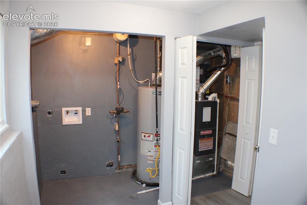 Image 24 of 28: Utility area featuring a water heater, furnace, and washer hookup