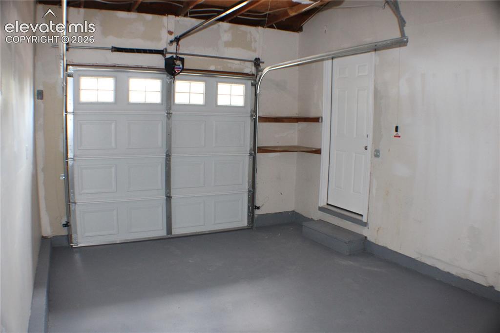 Image 26 of 28: Overhead garage door with upper-level windows