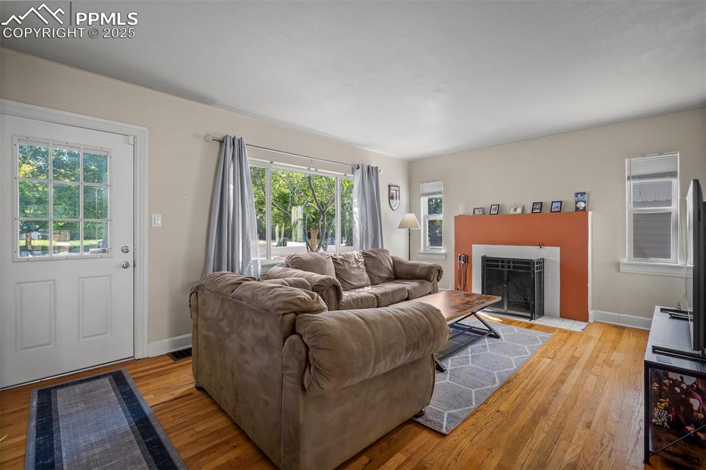 Image 6 of 47: LR with lots of light and wood-burning fireplace