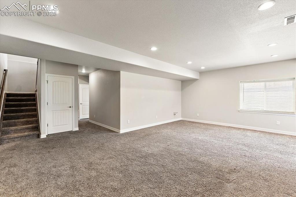 Image 18 of 48: Lower level family room and hallway to lower level Primary suite