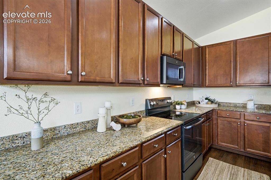 Image 10 of 45: Kitchen featuring wood-finish cabinetry, speckled countertops, stainless st